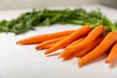 Ahşap kaplamalı havuç. Beyaz arka planda taze ve organik havuçlar. Havuç dilimleri. Vejetaryen. Salata için malzemeler. Mesaj için yer. Uzayı kopyala Düz