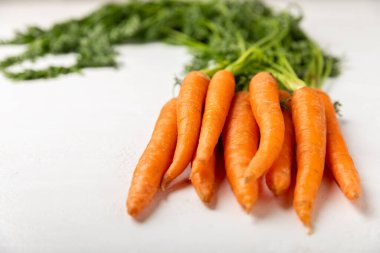 Ahşap kaplamalı havuç. Beyaz arka planda taze ve organik havuçlar. Havuç dilimleri. Vejetaryen. Salata için malzemeler. Mesaj için yer. Uzayı kopyala Düz