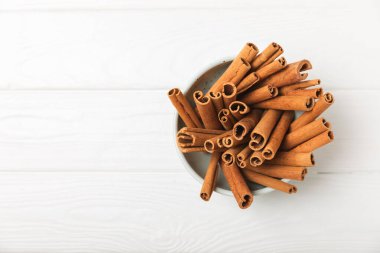 Tarçınlı çubuklar ahşap bir arka planda. Tarçınlı rulo. Fırın, tatlı ve içecekler için baharatlı baharat. Güzel kokulu tarçın. Tarçın tozu yakın plan. Mesaj için yer. Boşluğu kopyala