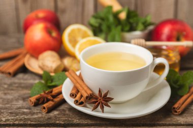 Tarçın sopasıyla kokulu sıcak çay ve ahşap bir arka planda anason. Ballı, limonlu, naneli ve elmalı bir fincan sıcak çay. Baharatlı baharatlı çay. Dokunulmazlık çayı. Sağlık kavramı. Boşluğu kopyala.