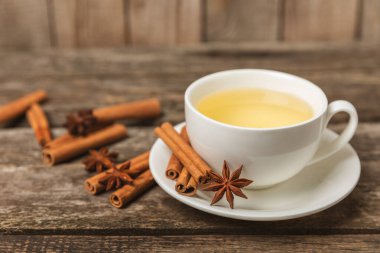 Tarçın sopasıyla kokulu sıcak çay ve ahşap bir arka planda anason. Ballı, limonlu, naneli ve elmalı bir fincan sıcak çay. Baharatlı baharatlı çay. Dokunulmazlık çayı. Sağlık kavramı. Boşluğu kopyala.