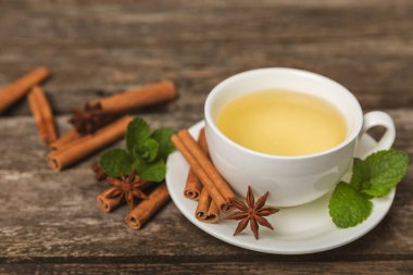 Tarçın sopasıyla kokulu sıcak çay ve ahşap bir arka planda anason. Ballı, limonlu, naneli ve elmalı bir fincan sıcak çay. Baharatlı baharatlı çay. Dokunulmazlık çayı. Sağlık kavramı. Boşluğu kopyala.