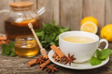 Tarçın sopasıyla kokulu sıcak çay ve ahşap bir arka planda anason. Ballı, limonlu, naneli ve elmalı bir fincan sıcak çay. Baharatlı baharatlı çay. Dokunulmazlık çayı. Sağlık kavramı. Boşluğu kopyala.