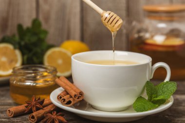 Tarçın sopasıyla kokulu sıcak çay ve ahşap bir arka planda anason. Ballı, limonlu, naneli ve elmalı bir fincan sıcak çay. Baharatlı baharatlı çay. Dokunulmazlık çayı. Sağlık kavramı. Boşluğu kopyala.