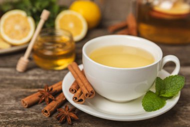 Tarçın sopasıyla kokulu sıcak çay ve ahşap bir arka planda anason. Ballı, limonlu, naneli ve elmalı bir fincan sıcak çay. Baharatlı baharatlı çay. Dokunulmazlık çayı. Sağlık kavramı. Boşluğu kopyala.