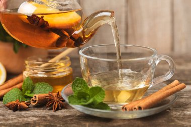 Tarçın sopasıyla kokulu sıcak çay ve ahşap bir arka planda anason. Ballı, limonlu, naneli ve elmalı bir fincan sıcak çay. Baharatlı baharatlı çay. Dokunulmazlık çayı. Sağlık kavramı. Boşluğu kopyala.