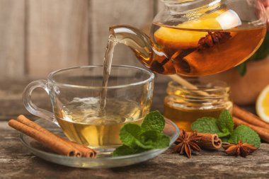 Tarçın sopasıyla kokulu sıcak çay ve ahşap bir arka planda anason. Ballı, limonlu, naneli ve elmalı bir fincan sıcak çay. Baharatlı baharatlı çay. Dokunulmazlık çayı. Sağlık kavramı. Boşluğu kopyala.