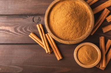 Ahşap kaplamalı tarçın tozu. Fırın, tatlı ve içecekler için baharatlı baharat. Güzel kokulu tarçın. Tarçın çubuğu. Mesaj için yer. Boşluğu kopyala.