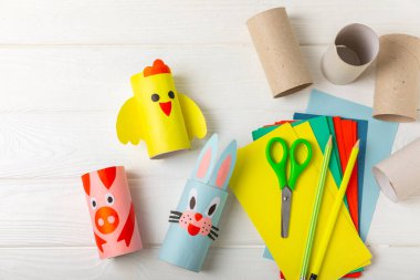 Renkli arka planda tuvalet kağıdı işçiliği. Tuvalet kağıdı rulosundan yapılmış çocuk el sanatları. DIY. El yapımı. Kağıt oyuncaklar. Origami hayvanları. Çocukların eğitici oyunları kavramı. Mesaj için yer. Boşluğu kopyala.