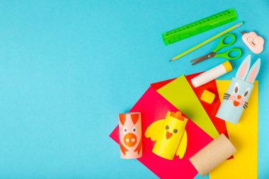 Renkli arka planda tuvalet kağıdı işçiliği. Tuvalet kağıdı rulosundan yapılmış çocuk el sanatları. DIY. El yapımı. Kağıt oyuncaklar. Origami hayvanları. Çocukların eğitici oyunları kavramı. Mesaj için yer. Boşluğu kopyala.