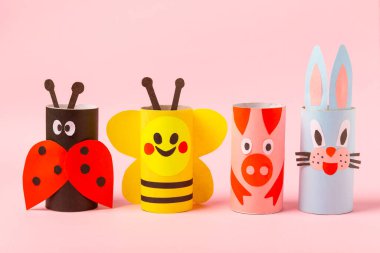 Renkli arka planda tuvalet kağıdı işçiliği. Tuvalet kağıdı rulosundan yapılmış çocuk el sanatları. DIY. El yapımı. Kağıt oyuncaklar. Origami hayvanları. Çocukların eğitici oyunları kavramı. Mesaj için yer. Boşluğu kopyala.