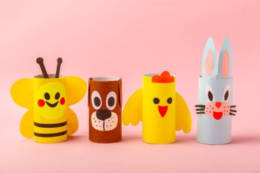 Renkli arka planda tuvalet kağıdı işçiliği. Tuvalet kağıdı rulosundan yapılmış çocuk el sanatları. DIY. El yapımı. Kağıt oyuncaklar. Origami hayvanları. Çocukların eğitici oyunları kavramı. Mesaj için yer. Boşluğu kopyala.