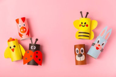 Renkli arka planda tuvalet kağıdı işçiliği. Tuvalet kağıdı rulosundan yapılmış çocuk el sanatları. DIY. El yapımı. Kağıt oyuncaklar. Origami hayvanları. Çocukların eğitici oyunları kavramı. Mesaj için yer. Boşluğu kopyala.