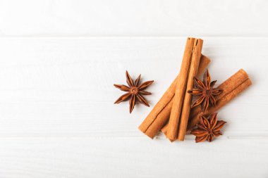 Tarçın çubukları ve anason desenli arka planda. Tarçınlı rulo ve yıldız anason. Fırın, tatlı ve içecekler için baharatlı baharat. Güzel kokulu tarçın. Mesaj için uygun bir yer. Boşluğu kopyala.