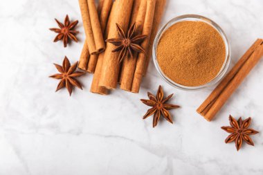 Tarçın çubukları ve anason desenli arka planda. Tarçınlı rulo ve yıldız anason. Fırın, tatlı ve içecekler için baharatlı baharat. Güzel kokulu tarçın. Mesaj için uygun bir yer. Boşluğu kopyala.