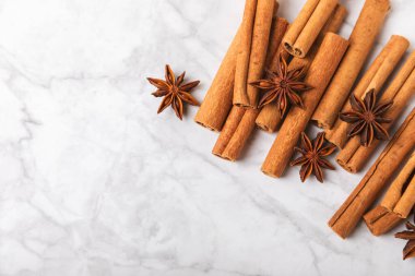 Tarçın çubukları ve anason desenli arka planda. Tarçınlı rulo ve yıldız anason. Fırın, tatlı ve içecekler için baharatlı baharat. Güzel kokulu tarçın. Mesaj için uygun bir yer. Boşluğu kopyala.