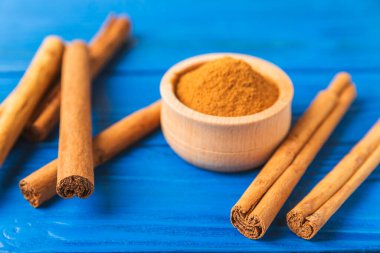 Seylan tarçın. Tarçın ahşap bir zemine yapışır. Tarçın rulosu ve pudra. Fırın, tatlı ve içecekler için baharatlı baharat. Güzel kokulu tarçın. Yakın plan. Mesaj için yer. Boşluğu kopyala