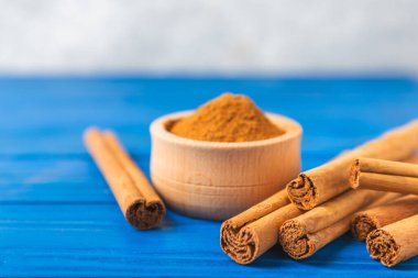 Seylan tarçın. Tarçın ahşap bir zemine yapışır. Tarçın rulosu ve pudra. Fırın, tatlı ve içecekler için baharatlı baharat. Güzel kokulu tarçın. Yakın plan. Mesaj için yer. Boşluğu kopyala