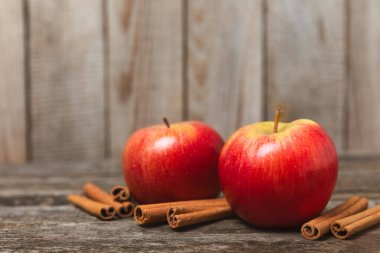 Tarçınlı elmalar ahşap kaplamalı. Tarçın çubukları ve yıldız anason ile kokulu kırmızı elmalar. Baharatlı elma dilimleri. Mesaj için yer. Uzayı kopyala Hasat. Meyveler. Vejetaryen.