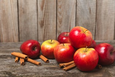 Tarçınlı elmalar ahşap kaplamalı. Tarçın çubukları ve yıldız anason ile kokulu kırmızı elmalar. Baharatlı elma dilimleri. Mesaj için yer. Uzayı kopyala Hasat. Meyveler. Vejetaryen.