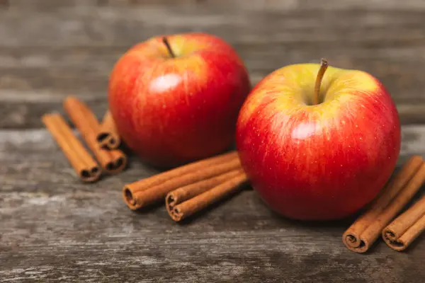 Jabłka Cynamonem Teksturowanym Drewnianym Tle Pachnące Czerwone Przyprawione Jabłka Kijami Obrazek Stockowy