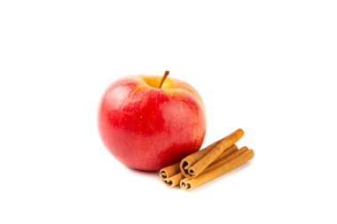 Tarçınlı elmalar beyaz arka planda izole edilmiş. Tarçın çubukları ve yıldız anason ile kokulu kırmızı elmalar. Baharatlı elma dilimleri. Mesaj için yer. Hasat. Meyveler. Vejetaryen.