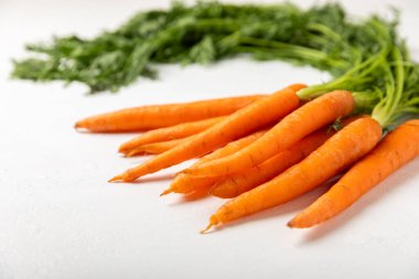 Ahşap kaplamalı havuç. Beyaz arka planda taze ve organik havuçlar. Havuç dilimleri. Vejetaryen. Salata için malzemeler. Mesaj için yer. Uzayı kopyala Düz