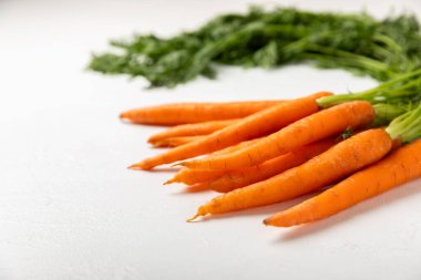 Ahşap kaplamalı havuç. Beyaz arka planda taze ve organik havuçlar. Havuç dilimleri. Vejetaryen. Salata için malzemeler. Mesaj için yer. Uzayı kopyala Düz