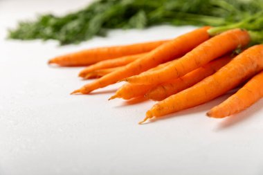 Ahşap kaplamalı havuç. Beyaz arka planda taze ve organik havuçlar. Havuç dilimleri. Vejetaryen. Salata için malzemeler. Mesaj için yer. Uzayı kopyala Düz