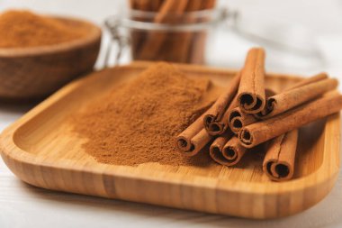 Tarçınlı çubuklar ahşap bir arka planda. Tarçınlı rulo. Fırın, tatlı ve içecekler için baharatlı baharat. Güzel kokulu tarçın. Tarçın tozu yakın plan. Mesaj için yer. Boşluğu kopyala