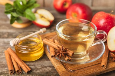 Tarçın sopasıyla kokulu sıcak çay ve ahşap bir arka planda anason. Ballı, limonlu, naneli ve elmalı bir fincan sıcak çay. Baharatlı baharatlı çay. Dokunulmazlık çayı. Sağlık kavramı. Boşluğu kopyala.