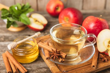 Tarçın sopasıyla kokulu sıcak çay ve ahşap bir arka planda anason. Ballı, limonlu, naneli ve elmalı bir fincan sıcak çay. Baharatlı baharatlı çay. Dokunulmazlık çayı. Sağlık kavramı. Boşluğu kopyala.