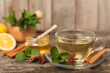 Tarçın sopasıyla kokulu sıcak çay ve ahşap bir arka planda anason. Ballı, limonlu, naneli ve elmalı bir fincan sıcak çay. Baharatlı baharatlı çay. Dokunulmazlık çayı. Sağlık kavramı. Boşluğu kopyala.