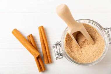 Tarçın şekeri arkaplanda. Arka planda bir kasede ev yapımı tarçın şekeri. Esmer şeker. İçecekler ve pişirme için baharat karışımı. Mesaj için yer. Boşluğu kopyala.