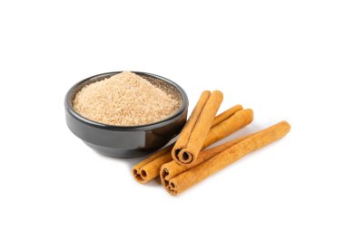 Tarçın şekeri beyaz arka planda izole edilmiş. Arka planda bir kasede ev yapımı tarçın şekeri. Esmer şeker. İçecekler ve pişirme için baharat karışımı..