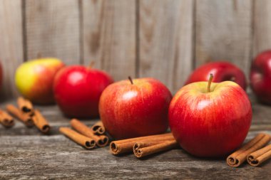 Tarçınlı elmalar ahşap kaplamalı. Tarçın çubukları ve yıldız anason ile kokulu kırmızı elmalar. Baharatlı elma dilimleri. Mesaj için yer. Uzayı kopyala Hasat. Meyveler. 