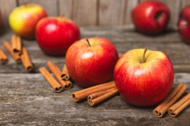 Tarçınlı elmalar ahşap kaplamalı. Tarçın çubukları ve yıldız anason ile kokulu kırmızı elmalar. Baharatlı elma dilimleri. Mesaj için yer. Uzayı kopyala Hasat. Meyveler. 