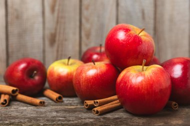 Tarçınlı elmalar ahşap kaplamalı. Tarçın çubukları ve yıldız anason ile kokulu kırmızı elmalar. Baharatlı elma dilimleri. Mesaj için yer. Uzayı kopyala Hasat. Meyveler. 