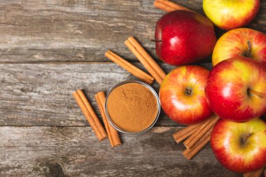 Tarçınlı elmalar ahşap kaplamalı. Tarçın çubukları ve yıldız anason ile kokulu kırmızı elmalar. Baharatlı elma dilimleri. Mesaj için yer. Uzayı kopyala Hasat. Meyveler. 