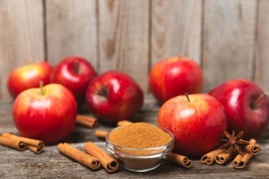 Tarçınlı elmalar ahşap kaplamalı. Tarçın çubukları ve yıldız anason ile kokulu kırmızı elmalar. Baharatlı elma dilimleri. Mesaj için yer. Uzayı kopyala Hasat. Meyveler. 