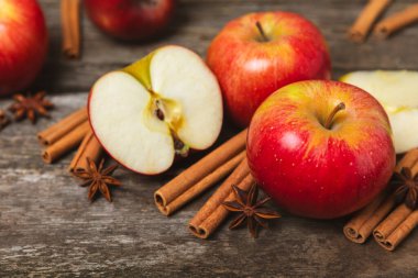 Tarçınlı elmalar ahşap kaplamalı. Tarçın çubukları ve yıldız anason ile kokulu kırmızı elmalar. Baharatlı elma dilimleri. Mesaj için yer. Uzayı kopyala Hasat. Meyveler. 