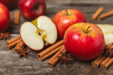 Tarçınlı elmalar ahşap kaplamalı. Tarçın çubukları ve yıldız anason ile kokulu kırmızı elmalar. Baharatlı elma dilimleri. Mesaj için yer. Uzayı kopyala Hasat. Meyveler. 