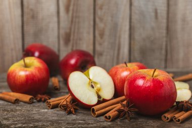 Tarçınlı elmalar ahşap kaplamalı. Tarçın çubukları ve yıldız anason ile kokulu kırmızı elmalar. Baharatlı elma dilimleri. Mesaj için yer. Uzayı kopyala Hasat. Meyveler. 