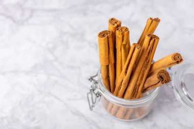 Seylan tarçın. Tarçın ahşap bir zemine yapışır. Tarçın rulosu ve pudra. Fırın, tatlı ve içecekler için baharatlı baharat. Güzel kokulu tarçın. Yakın plan. Mesaj için yer. Boşluğu kopyala