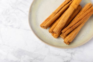 Seylan tarçın. Tarçın ahşap bir zemine yapışır. Tarçın rulosu ve pudra. Fırın, tatlı ve içecekler için baharatlı baharat. Güzel kokulu tarçın. Yakın plan. Mesaj için yer. Boşluğu kopyala