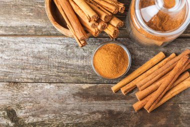 Seylan tarçın. Tarçın ahşap bir zemine yapışır. Tarçın rulosu ve pudra. Fırın, tatlı ve içecekler için baharatlı baharat. Güzel kokulu tarçın. Yakın plan. Mesaj için yer. Boşluğu kopyala