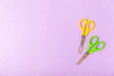 Renkli bir arka planda parlak çocuk makası. Kırtasiye malzemeleri. Okul için mallar. Mesaj için yer. Boşluğu kopyala. Üst görünüm