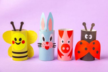 Renkli arka planda tuvalet kağıdı işçiliği. Tuvalet kağıdı rulosundan yapılmış çocuk el sanatları. DIY. El yapımı. Kağıt oyuncaklar. Origami hayvanları. Çocukların eğitici oyunları kavramı. Mesaj için yer. Boşluğu kopyala.