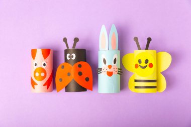 Renkli arka planda tuvalet kağıdı işçiliği. Tuvalet kağıdı rulosundan yapılmış çocuk el sanatları. DIY. El yapımı. Kağıt oyuncaklar. Origami hayvanları. Çocukların eğitici oyunları kavramı. Mesaj için yer. Boşluğu kopyala.