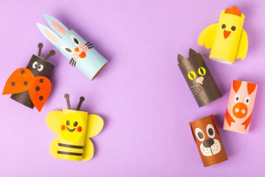 Renkli arka planda tuvalet kağıdı işçiliği. Tuvalet kağıdı rulosundan yapılmış çocuk el sanatları. DIY. El yapımı. Kağıt oyuncaklar. Origami hayvanları. Çocukların eğitici oyunları kavramı. Mesaj için yer. Boşluğu kopyala.